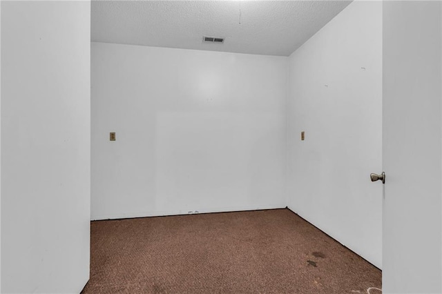 carpeted spare room with a textured ceiling
