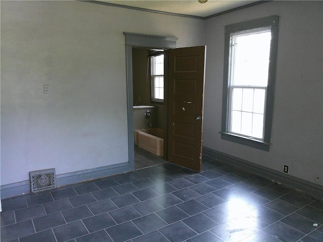 1107 Central St, Humboldt, KS 66748 - spare room featuring dark tile patterned flooring, baseboards, and a textured ceiling