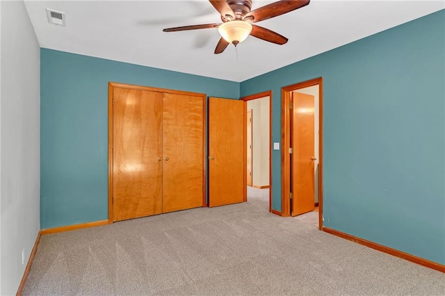 unfurnished bedroom featuring carpet floors, baseboards, a closet, and a ceiling fan