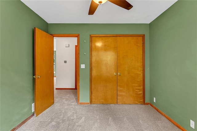 unfurnished bedroom featuring carpet, baseboards, ceiling fan, and a closet