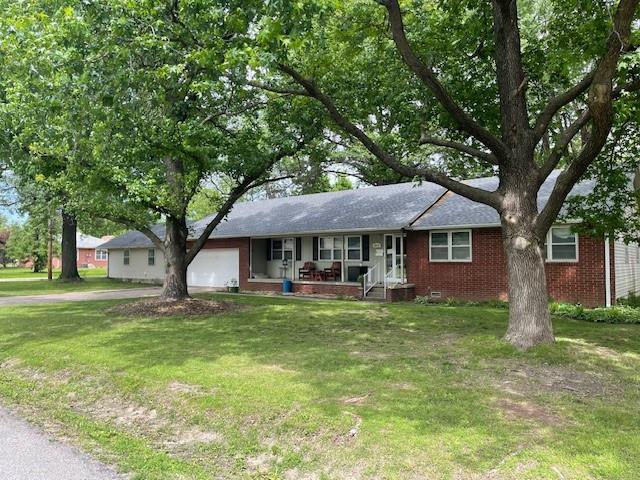 2002 N Michigan, Pittsburg, KS 66762 - ranch-style house featuring an attached garage, a porch, a front yard, brick siding, and driveway
