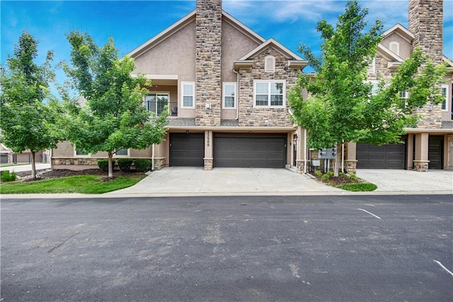 15908 Fontana St Unit 240, Overland Park, KS 66085 - view of property with stone siding, a chimney, stucco siding, an attached garage, and concrete driveway
