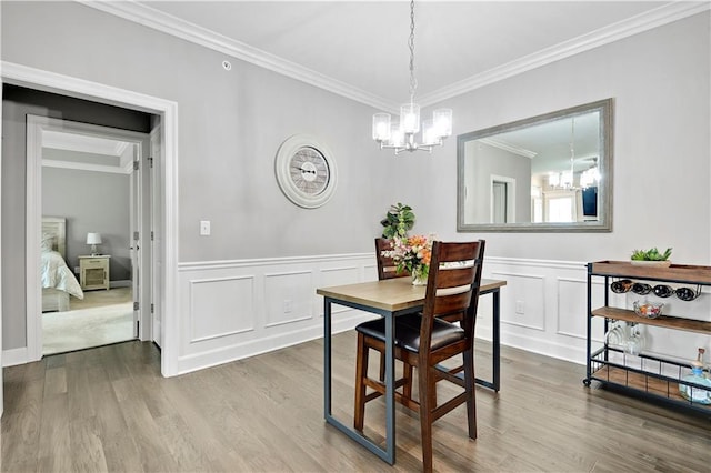 15908 Fontana St Unit 240, Overland Park, KS 66085 - dining area with a chandelier, crown molding, wood finished floors, a decorative wall, and a wainscoted wall