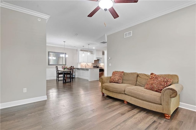 15908 Fontana St Unit 240, Overland Park, KS 66085 - living room featuring ceiling fan, ornamental molding, wood finished floors, baseboards, and a chandelier