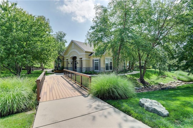 15908 Fontana St Unit 240, Overland Park, KS 66085 - view of property hidden behind natural elements with stone siding, stucco siding, and a front lawn