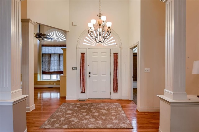 7100 N Cherry St, Gladstone, MO 64118 - foyer entrance with wood finished floors, a towering ceiling, baseboards, ornate columns, and a chandelier