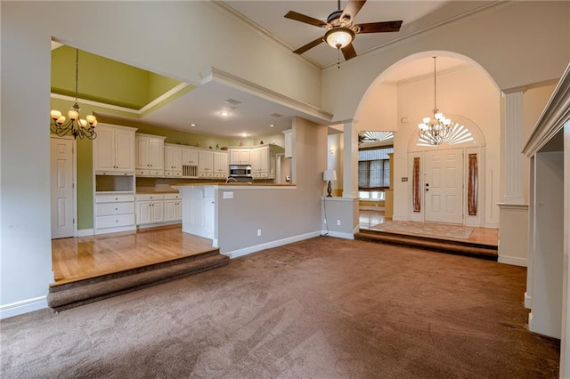 7100 N Cherry St, Gladstone, MO 64118 - unfurnished living room with a chandelier, carpet flooring, ornamental molding, baseboards, and a high ceiling