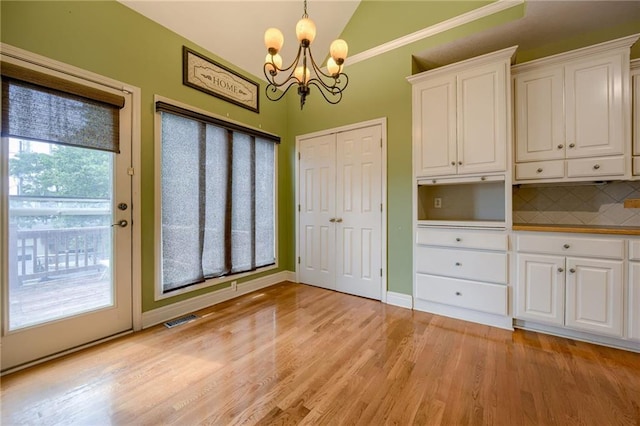 7100 N Cherry St, Gladstone, MO 64118 - unfurnished dining area featuring a chandelier, vaulted ceiling, and light wood-type flooring