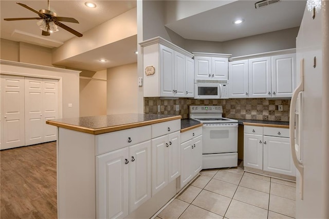 7100 N Cherry St, Gladstone, MO 64118 - kitchen featuring white appliances, dark countertops, white cabinetry, backsplash, and recessed lighting