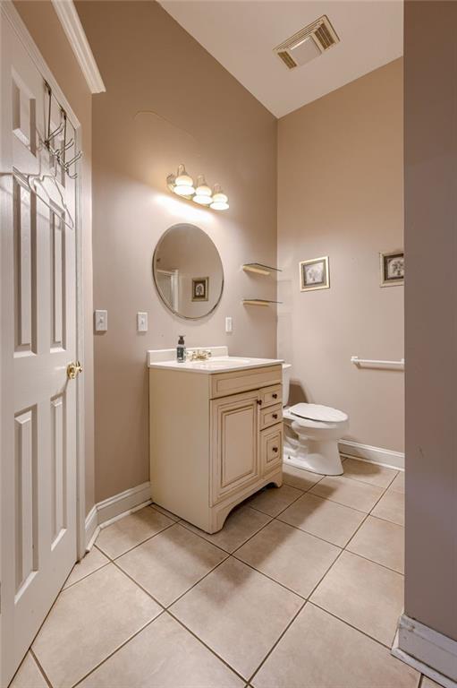 7100 N Cherry St, Gladstone, MO 64118 - bathroom featuring vanity, tile patterned floors, vaulted ceiling, toilet, and baseboards