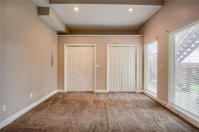 7100 N Cherry St, Gladstone, MO 64118 - unfurnished bedroom featuring multiple closets, carpet floors, baseboards, recessed lighting, and access to exterior