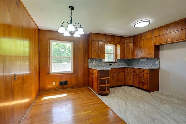 3001 S Hardy Ave, Independence, MO 64052 - kitchen featuring brown cabinets, tasteful backsplash, a chandelier, open shelves, and light wood-type flooring