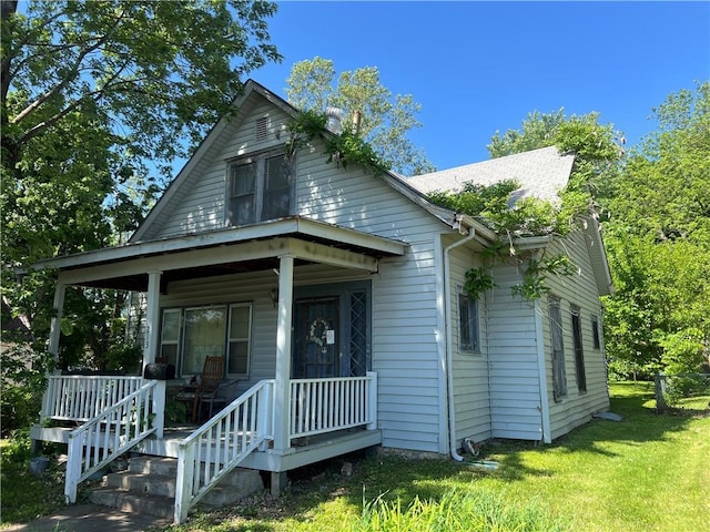 bungalow with covered porch and a front lawn