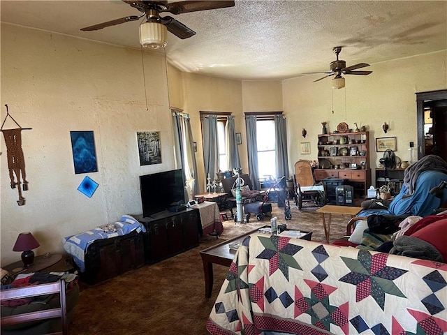 carpeted living area featuring a ceiling fan and a textured ceiling