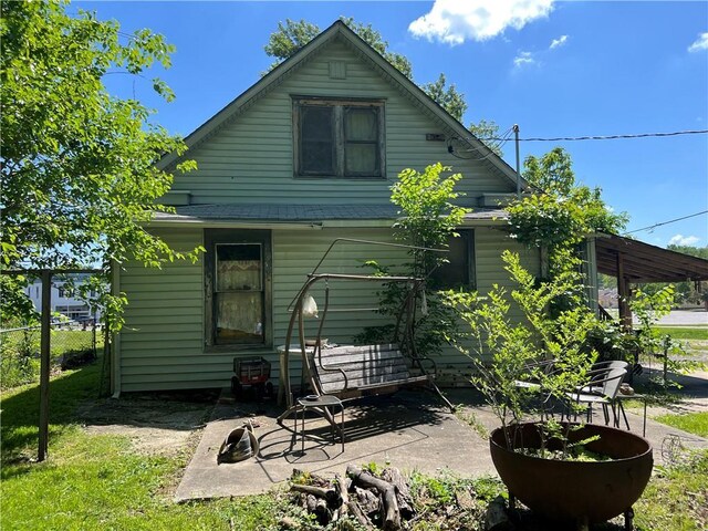 rear view of house with a patio and fence