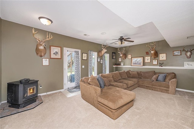 11028 N Tullis Ct, Kansas City, MO 64157 - carpeted living area with a wood stove, baseboards, and a ceiling fan