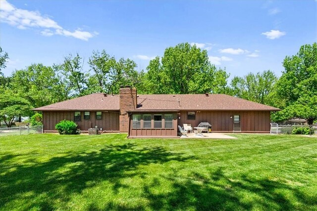 2107 N 154th Ter, Basehor, KS 66007 - back of house with a patio area, a chimney, board and batten siding, and a shingled roof