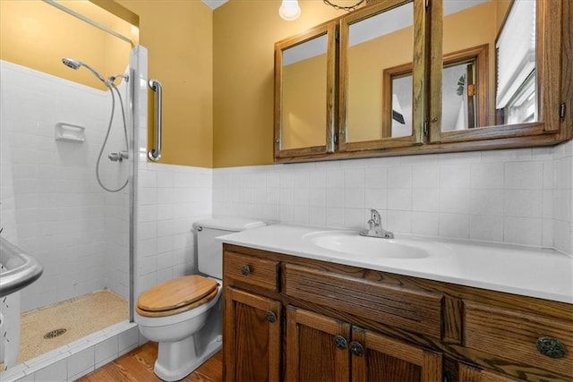 2107 N 154th Ter, Basehor, KS 66007 - bathroom with toilet, a tile shower, vanity, wood finished floors, and wainscoting