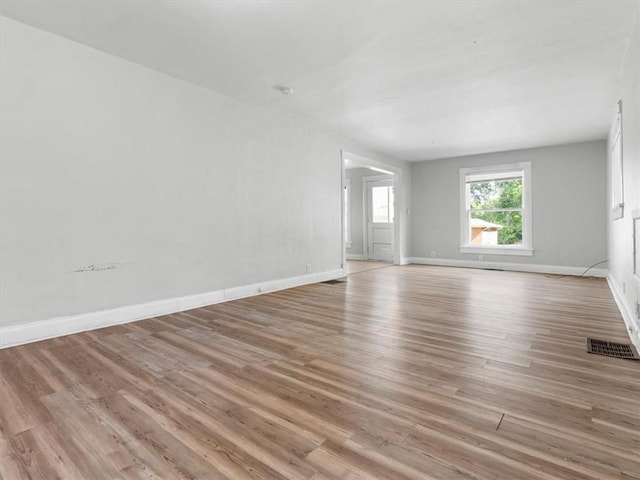 spare room featuring light wood-style floors and baseboards