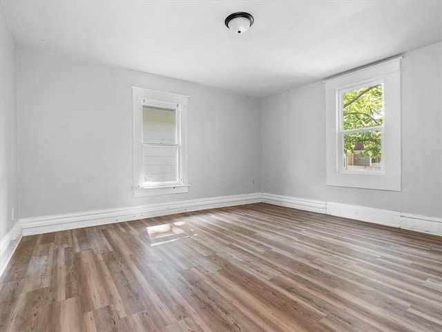 empty room featuring wood finished floors and baseboards