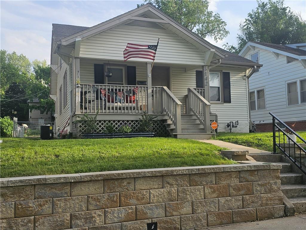 3142 Felix St, Saint Joseph, MO 64501 - view of front of home with covered porch, central AC unit, and a front yard