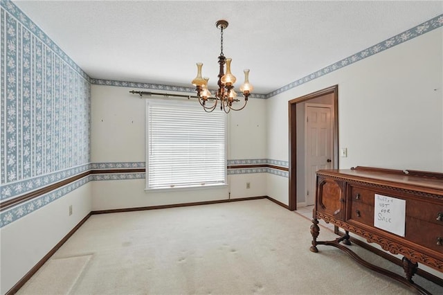 spare room with a chandelier, wallpapered walls, carpet, baseboards, and a textured ceiling