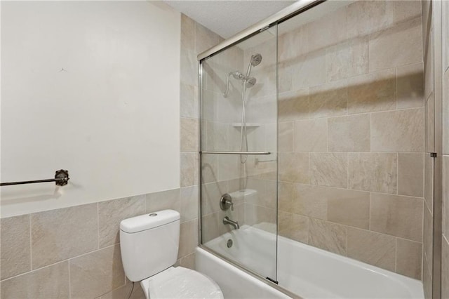 bathroom with enclosed tub / shower combo, tile walls, and toilet
