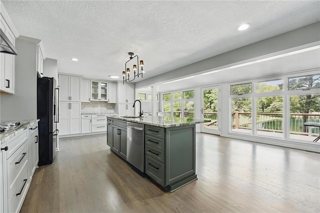11203 Cedar St, Leawood, KS 66211 - kitchen featuring stainless steel appliances, a sink, dark wood finished floors, a textured ceiling, and white cabinets