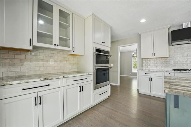 11203 Cedar St, Leawood, KS 66211 - kitchen featuring double oven, glass insert cabinets, wood finished floors, white cabinetry, and baseboards