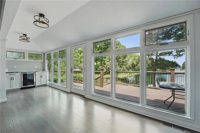 11203 Cedar St, Leawood, KS 66211 - unfurnished sunroom with beverage cooler, plenty of natural light, a deck with water view, wood finished floors, and vaulted ceiling