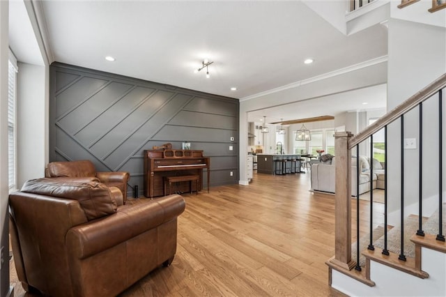 4813 NE Jamestown Dr, Lees Summit, MO 64064 - living area with stairs, light wood-style flooring, crown molding, a decorative wall, and recessed lighting