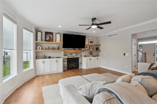 4813 NE Jamestown Dr, Lees Summit, MO 64064 - living area with crown molding, light wood finished floors, a ceiling fan, plenty of natural light, and a stone fireplace