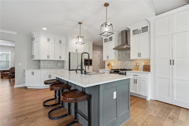 4813 NE Jamestown Dr, Lees Summit, MO 64064 - kitchen featuring wall chimney range hood, recessed lighting, light countertops, gas stove, and light wood finished floors