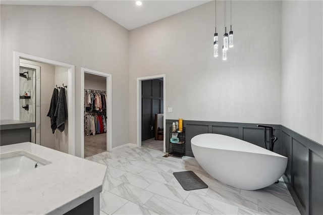 4813 NE Jamestown Dr, Lees Summit, MO 64064 - full bath with a freestanding tub, vanity, marble look tile flooring, high vaulted ceiling, and a walk in closet