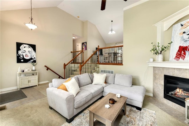 1200 SW Creekside Dr, Lees Summit, MO 64081 - living room with ceiling fan, high vaulted ceiling, baseboards, a tiled fireplace, and stairs