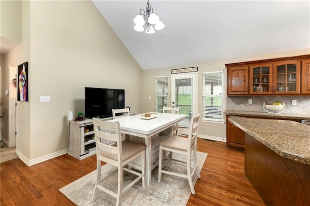 1200 SW Creekside Dr, Lees Summit, MO 64081 - dining space featuring wood finished floors, a chandelier, baseboards, and high vaulted ceiling