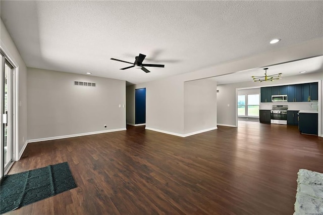 7826 Haskell Dr, Kansas City, KS 66109 - unfurnished living room with dark wood finished floors, a textured ceiling, a chandelier, baseboards, and recessed lighting