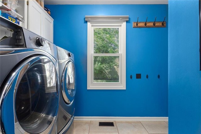 17699 157th Ter, Basehor, KS 66007 - laundry area featuring washing machine and dryer, cabinet space, light tile patterned flooring, and baseboards
