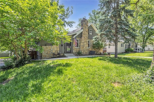 obstructed view of property featuring stone siding, a front lawn, and a chimney