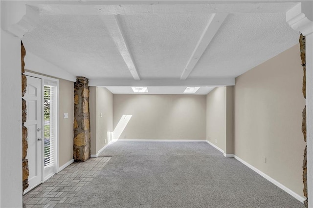 below grade area featuring a textured ceiling, baseboards, and carpet