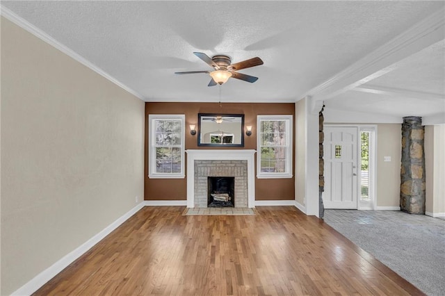 unfurnished living room featuring a textured ceiling, crown molding, baseboards, wood finished floors, and ceiling fan