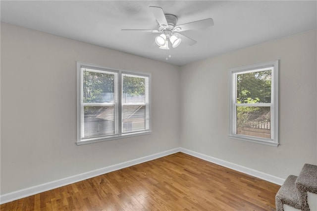 unfurnished room featuring baseboards, light wood-style floors, and a ceiling fan