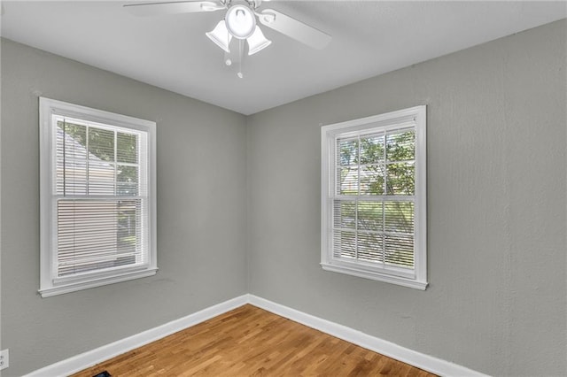 empty room featuring light wood finished floors, baseboards, and ceiling fan