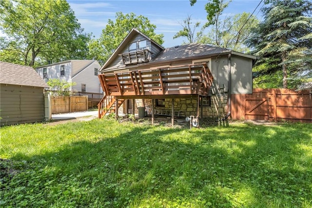 back of house with stairs, a deck, and a shingled roof