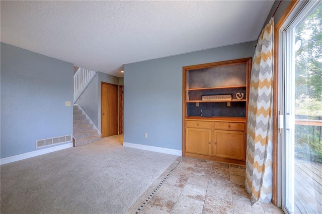 4729 Halsey St, Shawnee, KS 66216 - spare room featuring stairs, a textured ceiling, and light colored carpet
