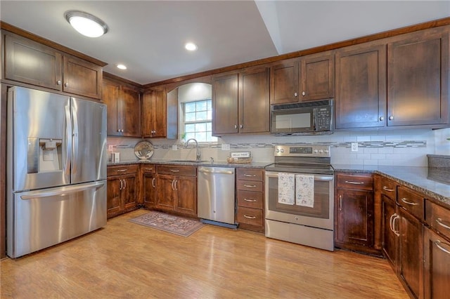 4729 Halsey St, Shawnee, KS 66216 - kitchen with appliances with stainless steel finishes, decorative backsplash, light wood finished floors, dark stone counters, and recessed lighting