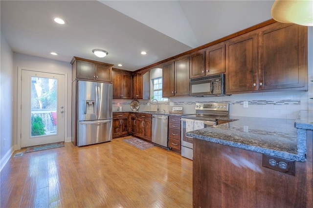 4729 Halsey St, Shawnee, KS 66216 - kitchen with stainless steel appliances, light wood-style flooring, decorative backsplash, dark stone counters, and recessed lighting
