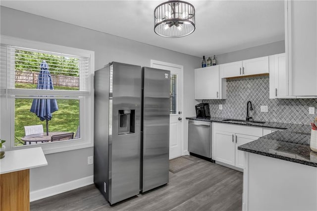 835 N 83rd Dr, Kansas City, KS 66112 - kitchen featuring appliances with stainless steel finishes, a sink, decorative backsplash, and white cabinetry