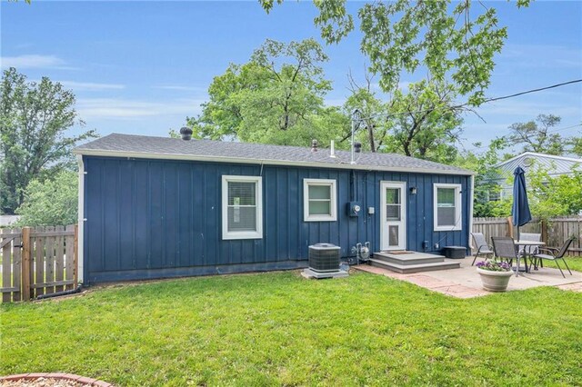 835 N 83rd Dr, Kansas City, KS 66112 - back of house featuring board and batten siding, a patio, central AC, and roof with shingles