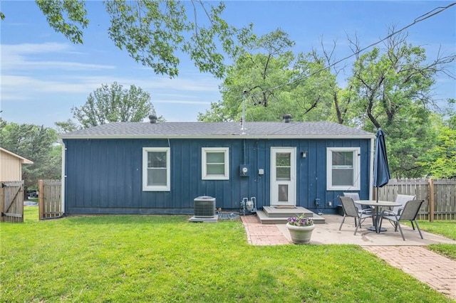 835 N 83rd Dr, Kansas City, KS 66112 - back of house featuring board and batten siding, a shingled roof, a patio area, and central AC